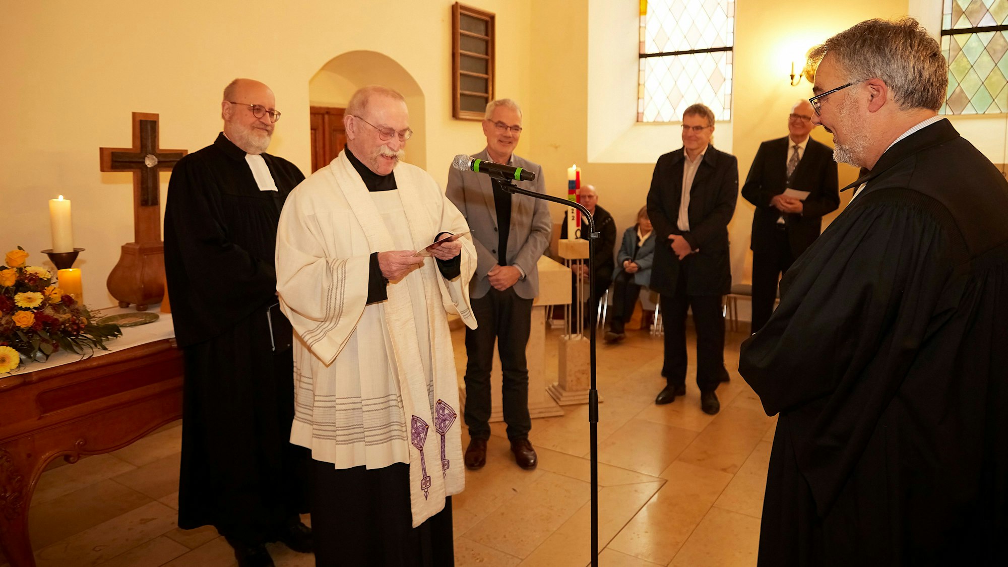 Der katholische Pfarrer Philipp Cuck spricht vor Erik Schumacher in der Kirche einen Segensgruß.
