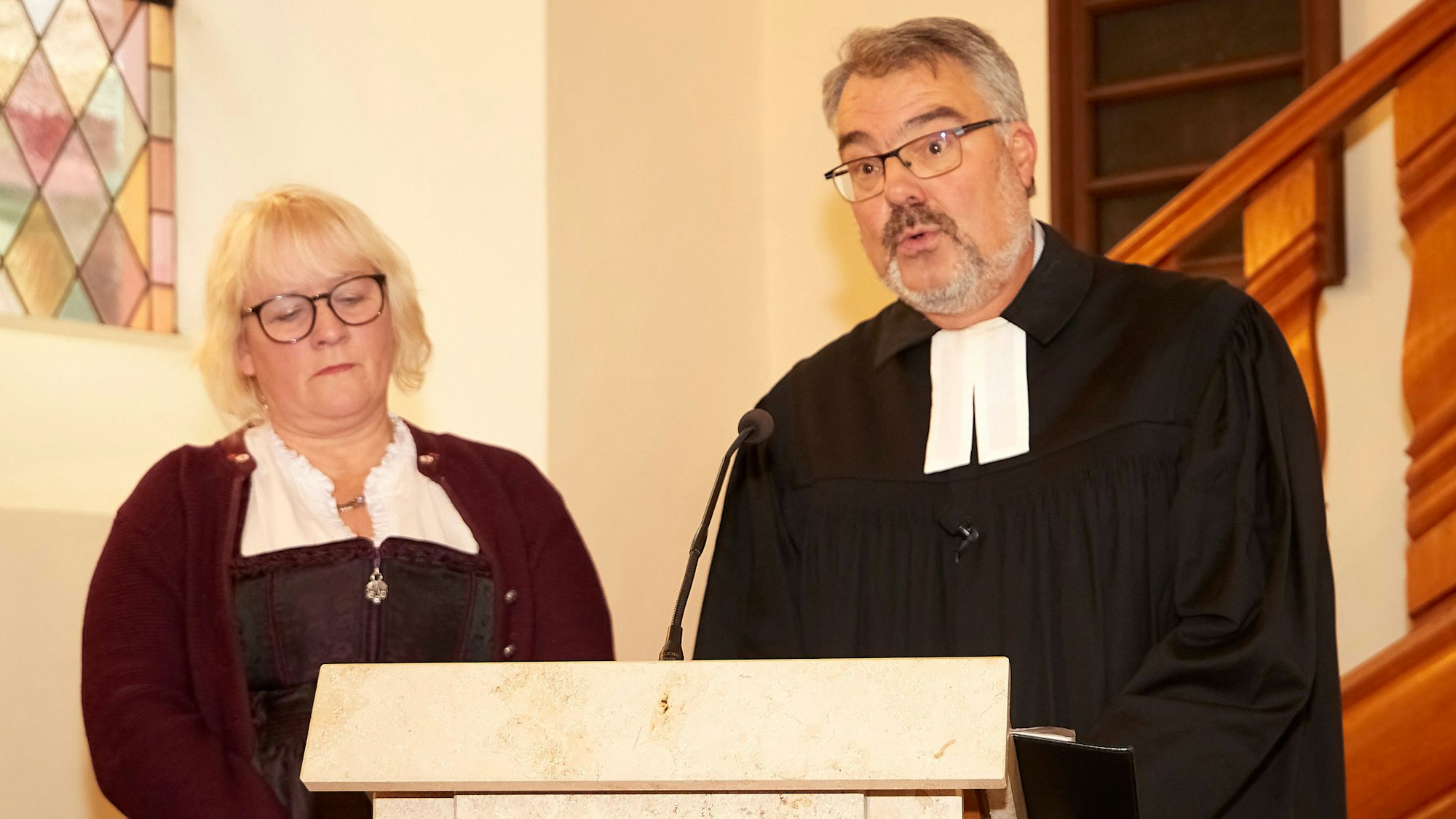 Ehefrau Heike und Pfarrer Erik Schumacher am Rednerpult in der Kirche.
