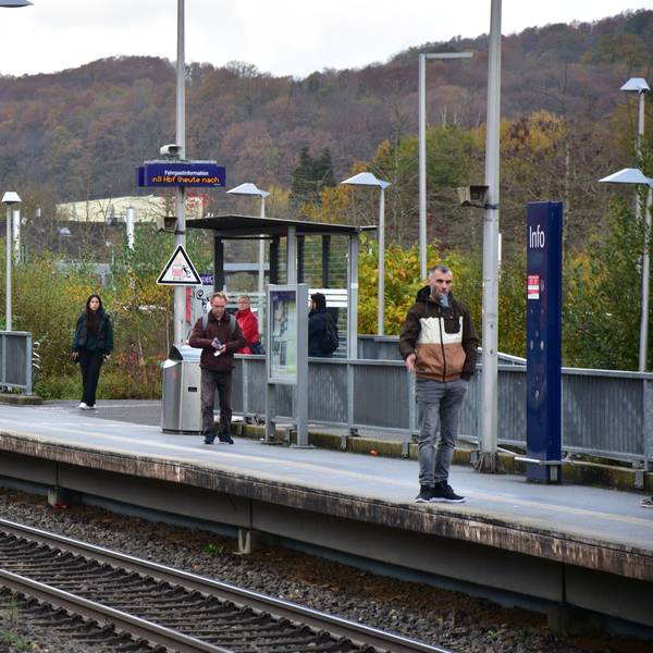 Auf einem Bahnsteig stehen mehrere Personen.