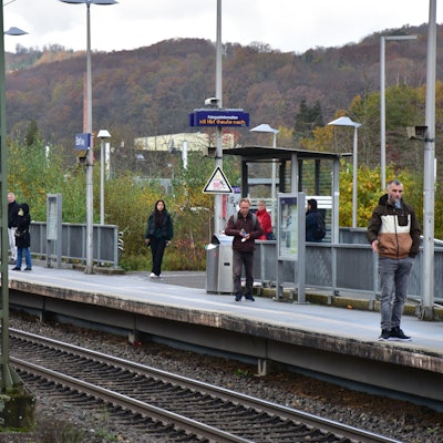 Auf einem Bahnsteig stehen mehrere Personen.