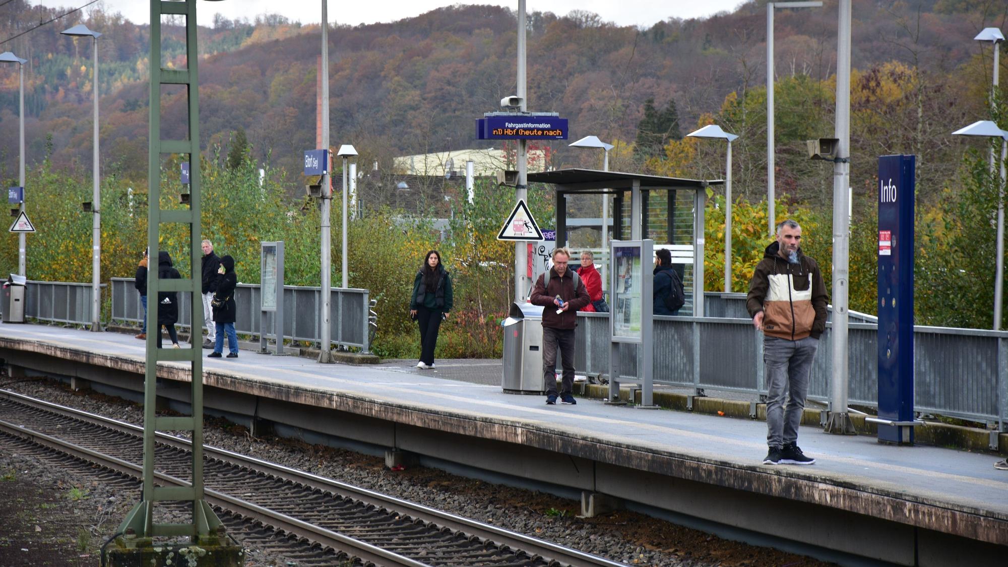 Auf einem Bahnsteig stehen mehrere Personen.