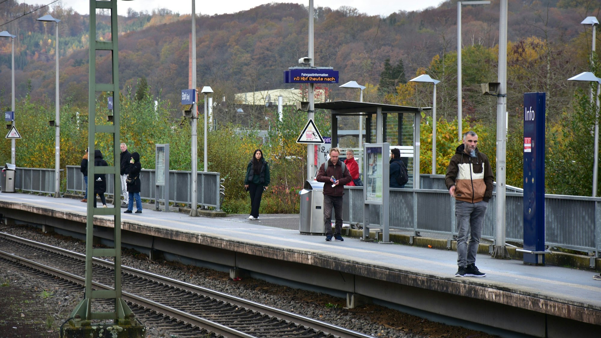 Auf einem Bahnsteig stehen mehrere Personen.
