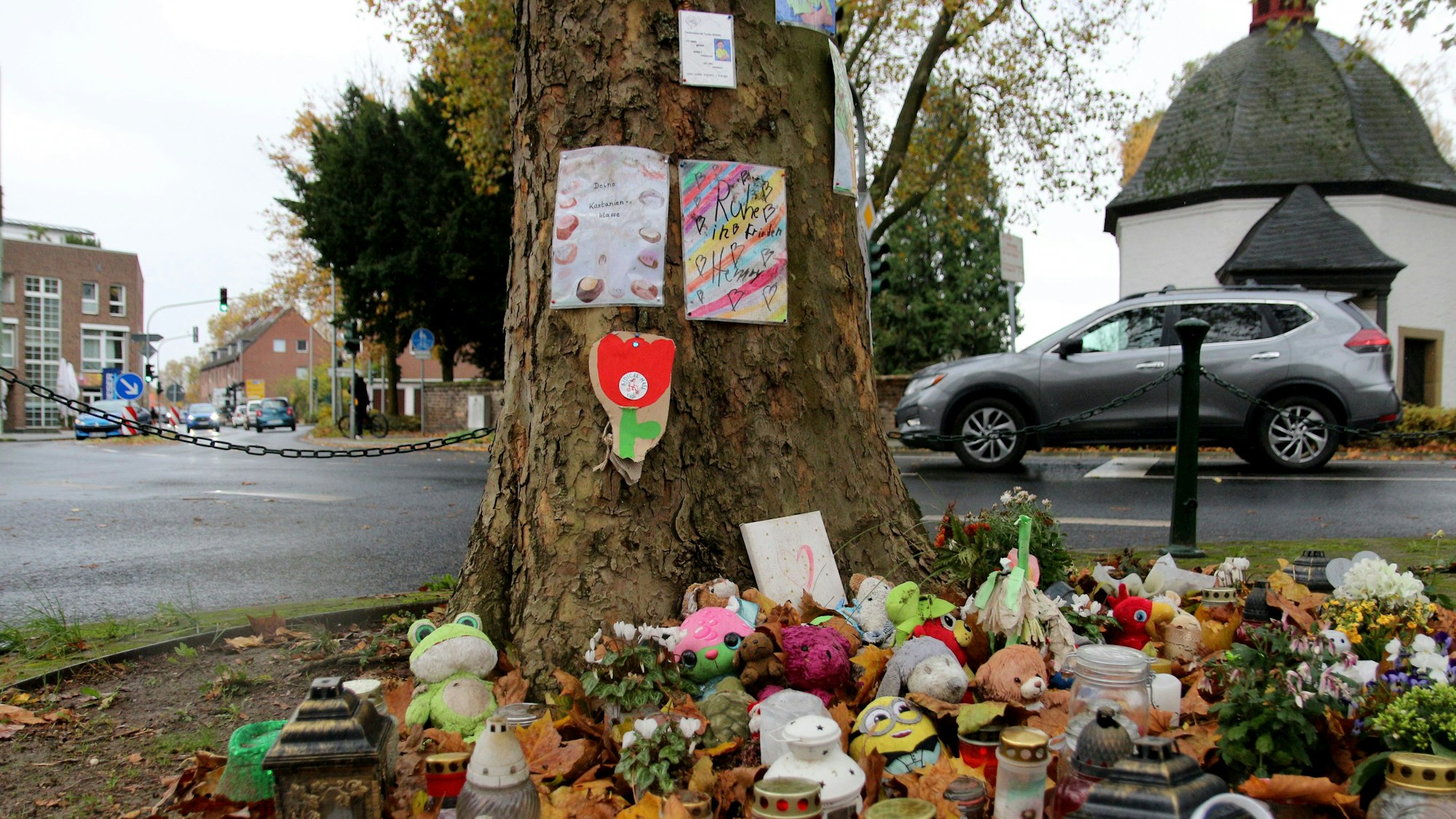 Am Fuß eines Baumes stehen viele Kerzen und kleine Geschenke, am Stamm hängen Texte zur Erinnerung an den verunglückten Jungen.