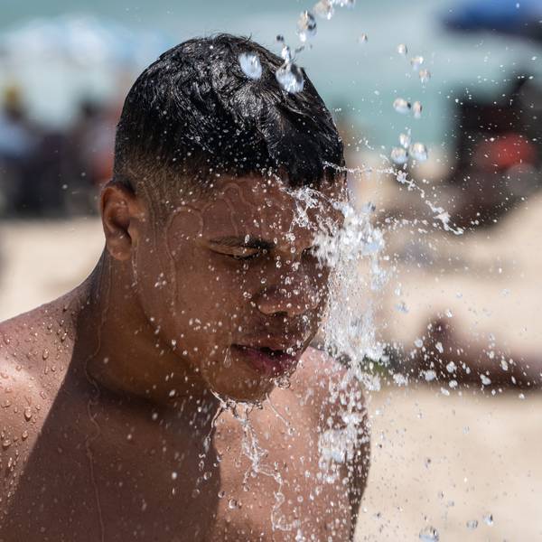 14.11.2023, Brasilien, Rio De Janeiro: Ein Mann duscht am Strand von Ipanema. Brasilien wird derzeit von einer Hitzewelle heimgesucht. Foto: Wang Tiancong/XinHua/dpa +++ dpa-Bildfunk +++