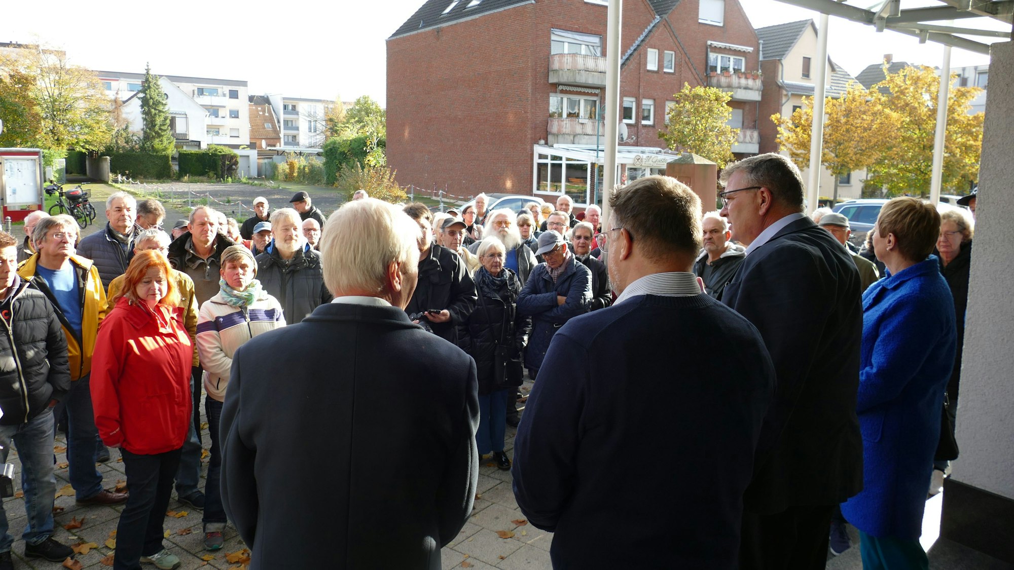 Der ehemalige Niederkasseler Bürgermeister Stephan Vehreschild diskutiert vor dem Rathaus mit Bürgerinnen und Bürgern, die gegen die Erhöhung der Grundsteuer B protestieren.