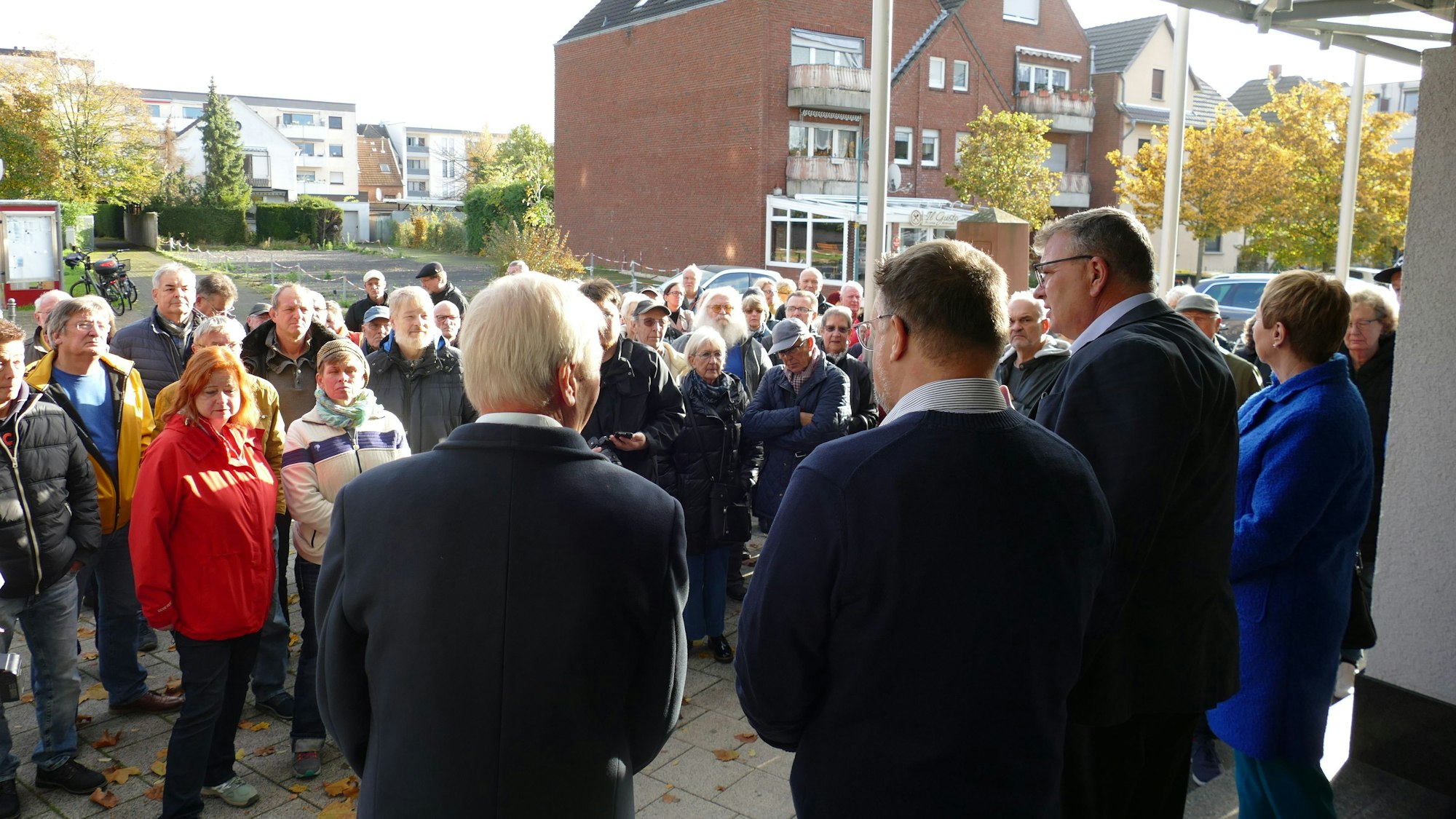 Viele Menschen stehen vor dem Eingang zum Rathaus, der Bürgermeister und andere stehen davor.