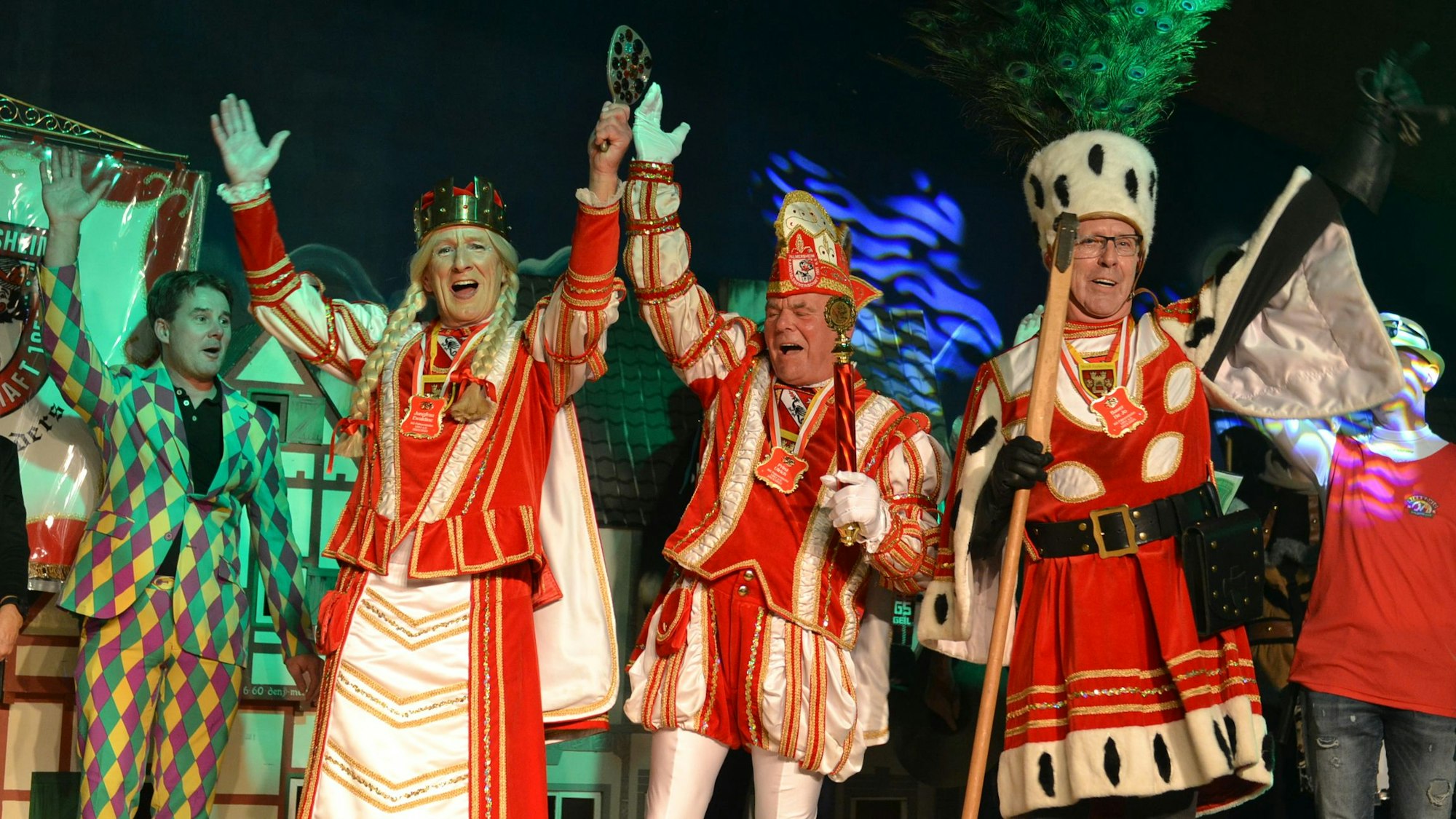 Das Bild zeigt das Palmersheimer Dreigestirn kurz nach der Proklamation auf der Bühne. Sie reißen die Arme hoch.