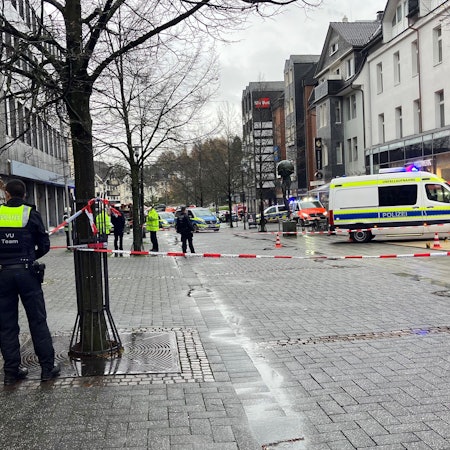 Mehrere Polizeiautos, Absperrband und Rettungswagen im Einsatz.