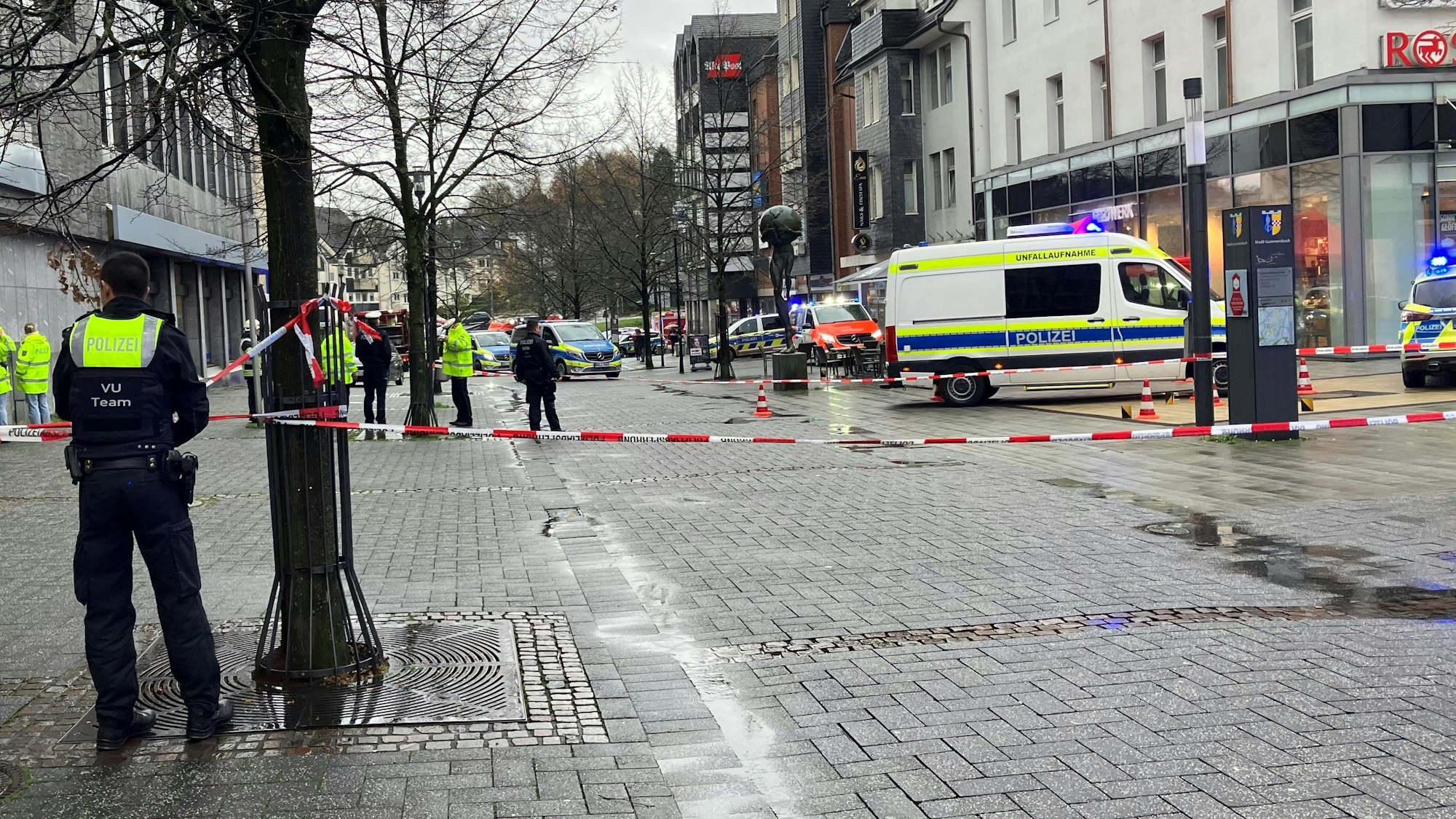 Mehrere Polizeiautos, Absperrband und Rettungswagen im Einsatz.