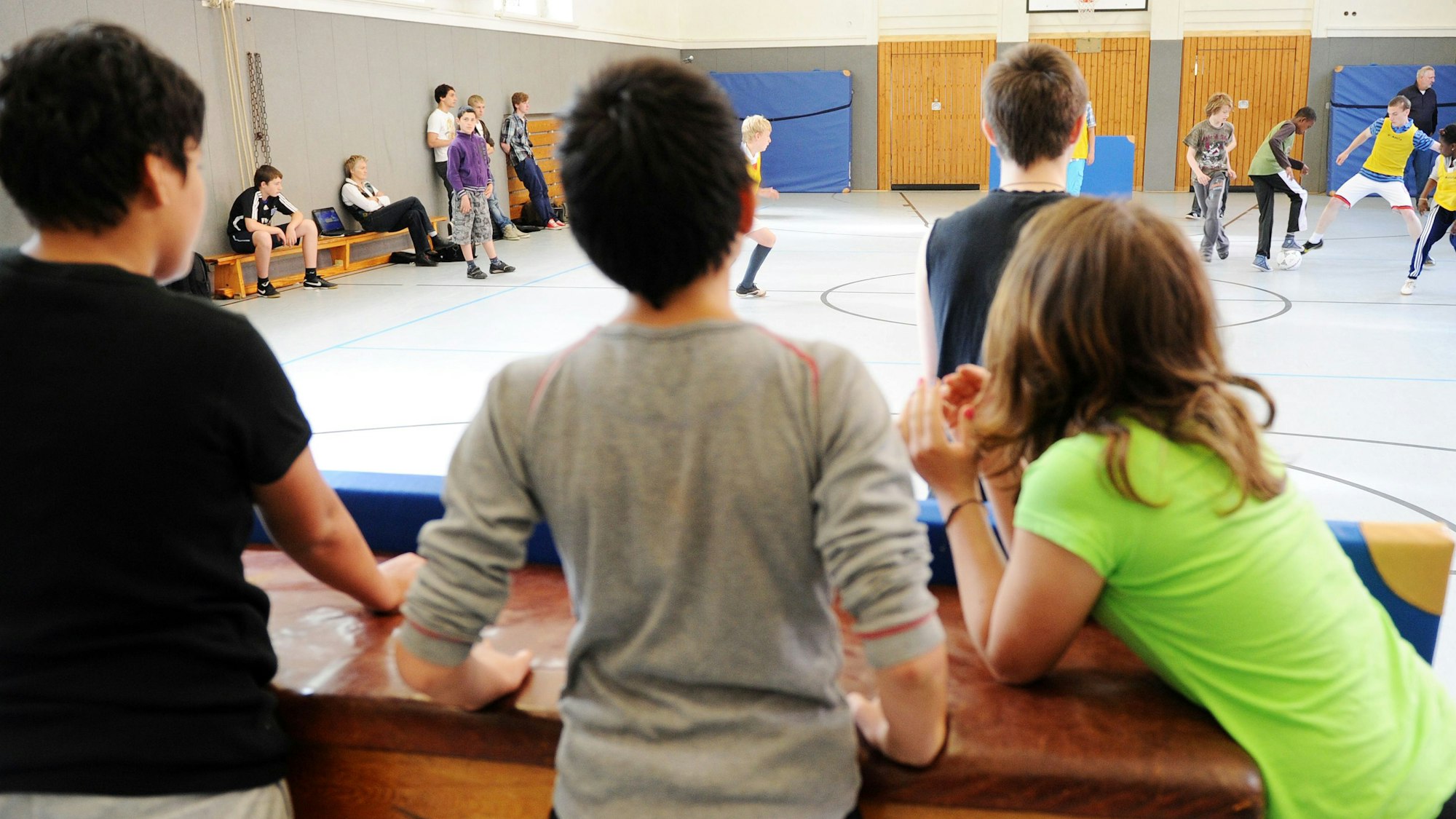 Schülerinnen und Schüler in einer Sporthalle.