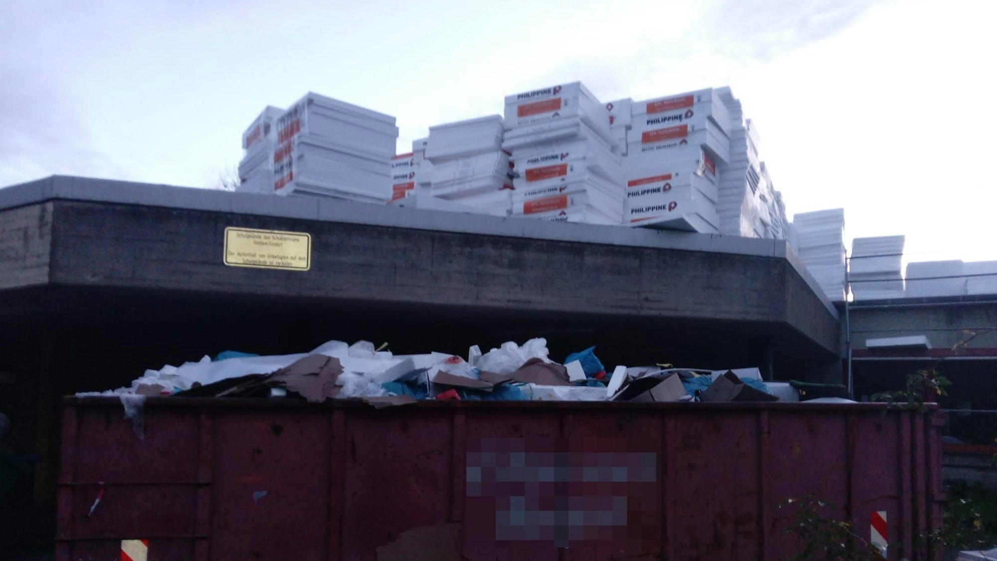 Auf dem Dach eines Gesamtschulgebäudes liegt Baumaterial.