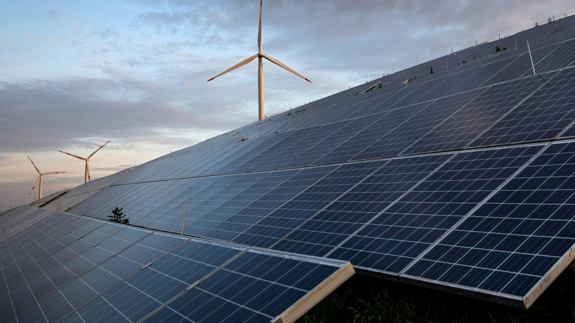 ARCHIV - 23.05.2022, Bremen: Windkraftanlagen stehen hinter Photovoltaikanlagen auf der Blocklanddeponie. (zu dpa «Niedersachsen rechnet mit Verdopplung des Solar-Zubaus») Foto: Sina Schuldt/dpa +++ dpa-Bildfunk +++