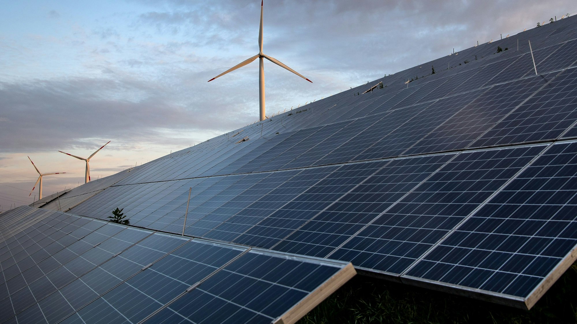 ARCHIV - 23.05.2022, Bremen: Windkraftanlagen stehen hinter Photovoltaikanlagen auf der Blocklanddeponie. (zu dpa «Niedersachsen rechnet mit Verdopplung des Solar-Zubaus») Foto: Sina Schuldt/dpa +++ dpa-Bildfunk +++