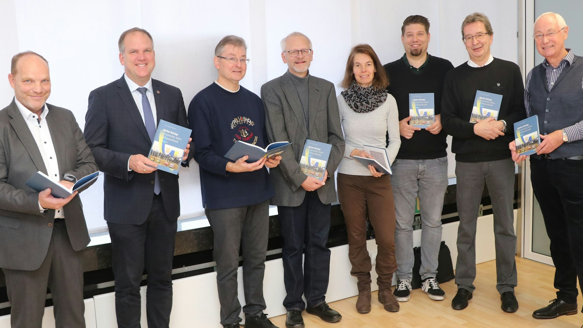 Männer und Frauen halten ein Buch in den Händen.