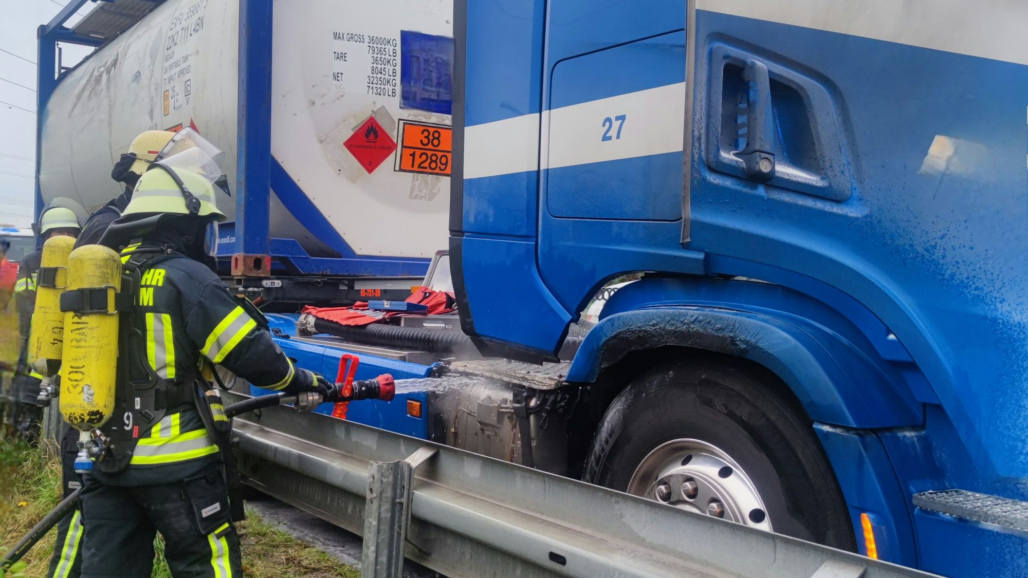 Auf dem Foto ist zu sehen, wie Feuerwehrleute die Zugmaschine eines Lkw mit Wasser kühlen.