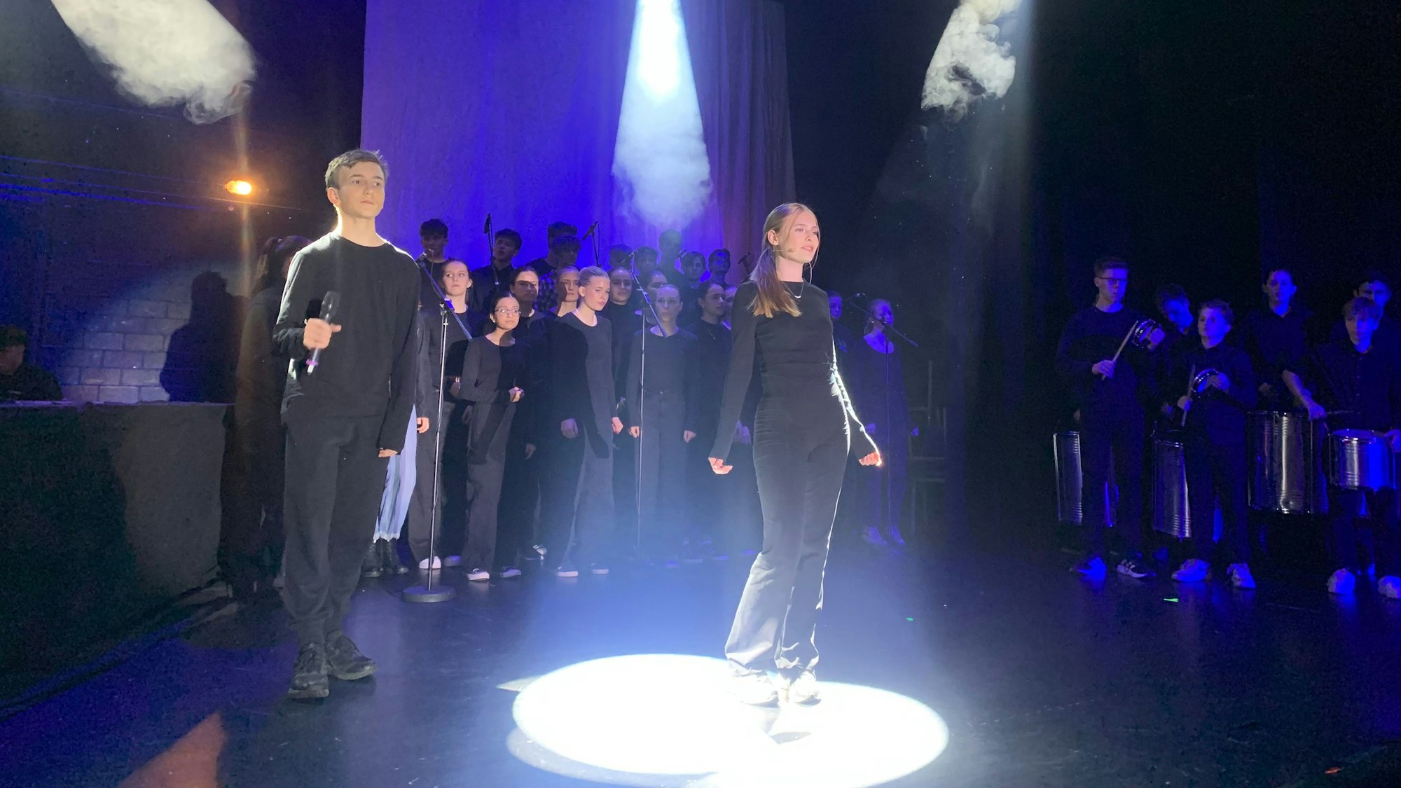 Der Chor singt auf der Bühne beim Oberstufenmusical Chasing Shadow am Rhein-Sieg-Gymnasium in Sankt Augustin.