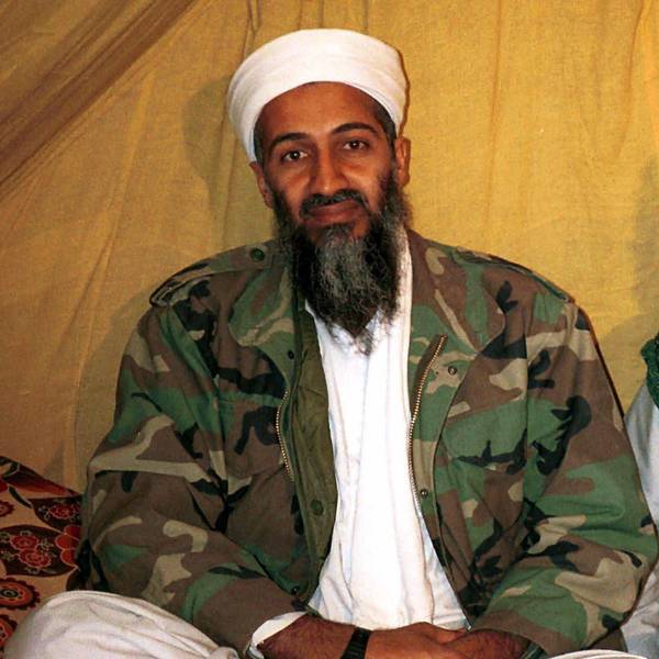 Osama bin Laden in Camouflage-Jacke vor einem hellen Hintergrund