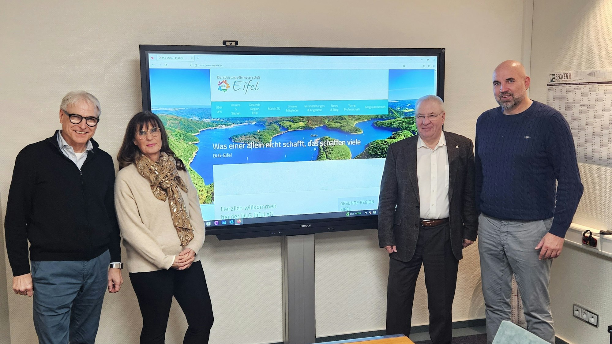 Edmund Komar (v.l.), Petra Schumacher-Hendus, Bernd Becker und Hubert Schmidt stehen vor einem großen Monitor.
