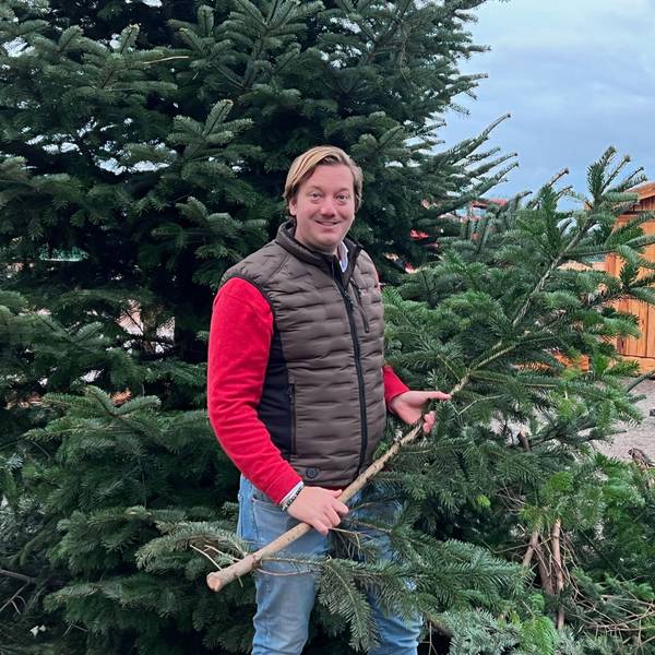 Das Bild zeigt Victor Dünn, der Inhaber von Gut Clarenhof, vor einem Weihnachtsbaum.