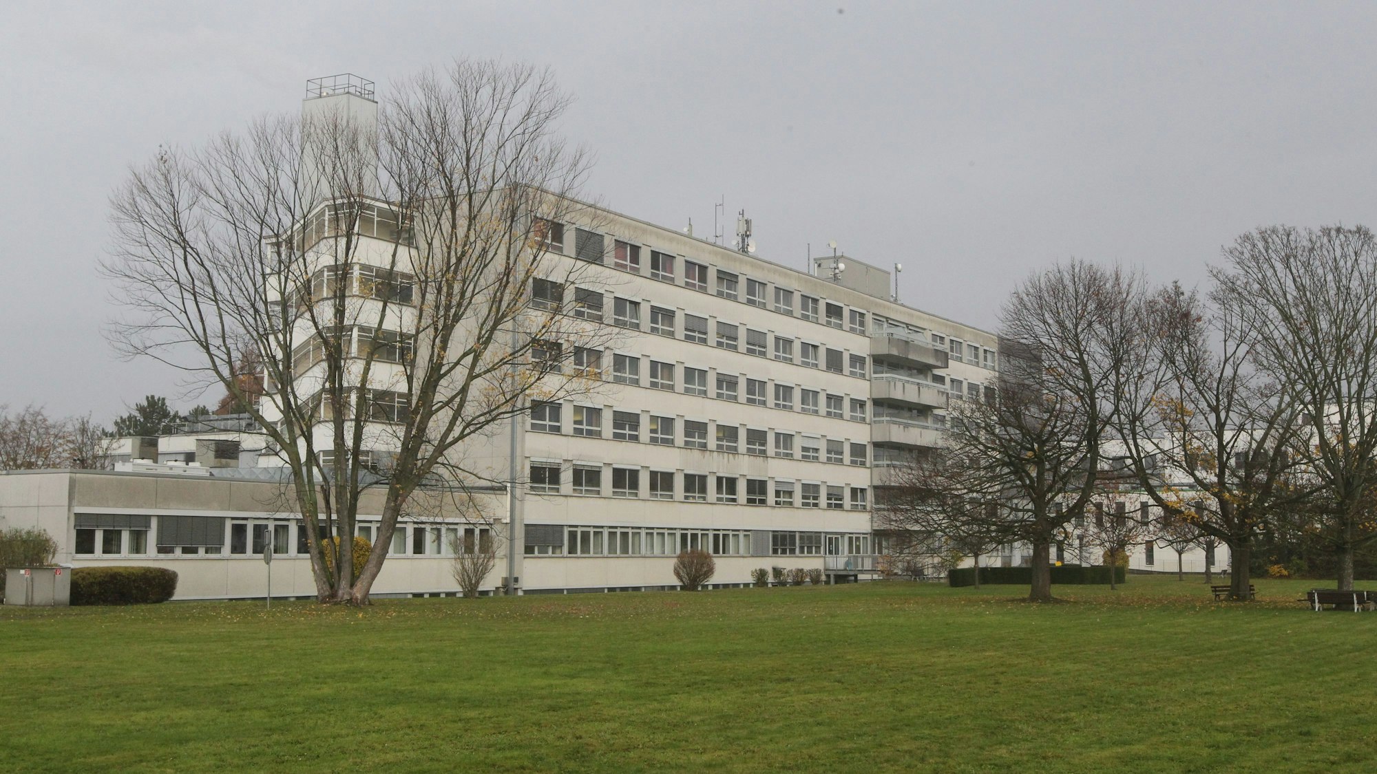 Eine Rasenfläche, im Hintergrund ein mehrgeschossiges Krankenhausgebäude.