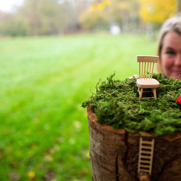 Im Vordergrund befindet sich eine Miniaturlandschaft mit Fliegenpilzen und einem Stuhl, dahinter ist leicht unscharf Julia Mostert zu sehen.