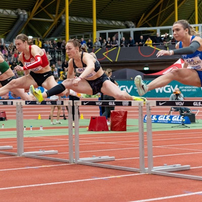 Das Bild zeigt fünf Sportlerinnen beim Hürdenlauf.