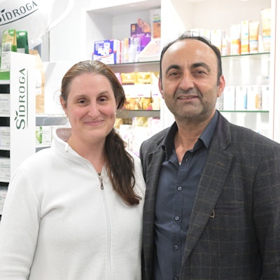 Isabel Hanisch-Alsultan und Azam Alsultan stehen nebeneinander vor einem Regal mit Medikamenten.