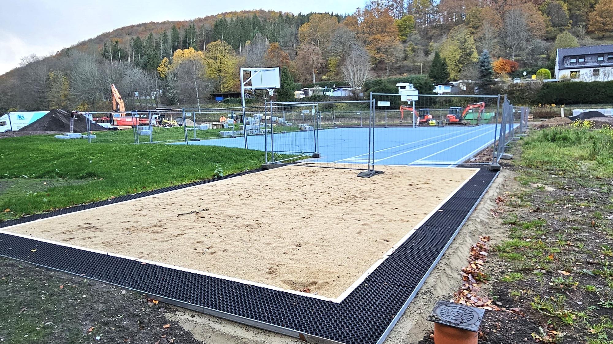 Im Vordergrund ist die Weitsprunggrube und dahinter das Basketballfeld zu sehen.