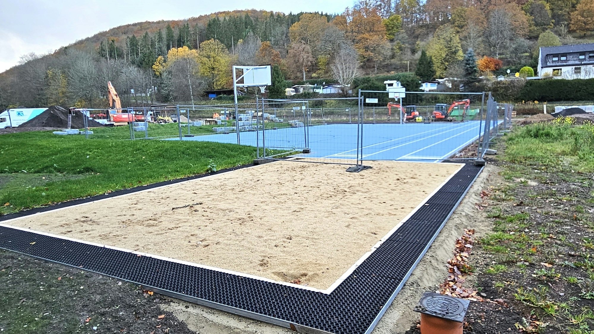 Im Vordergrund ist die Weitsprunggrube und dahinter das Basketballfeld zu sehen.