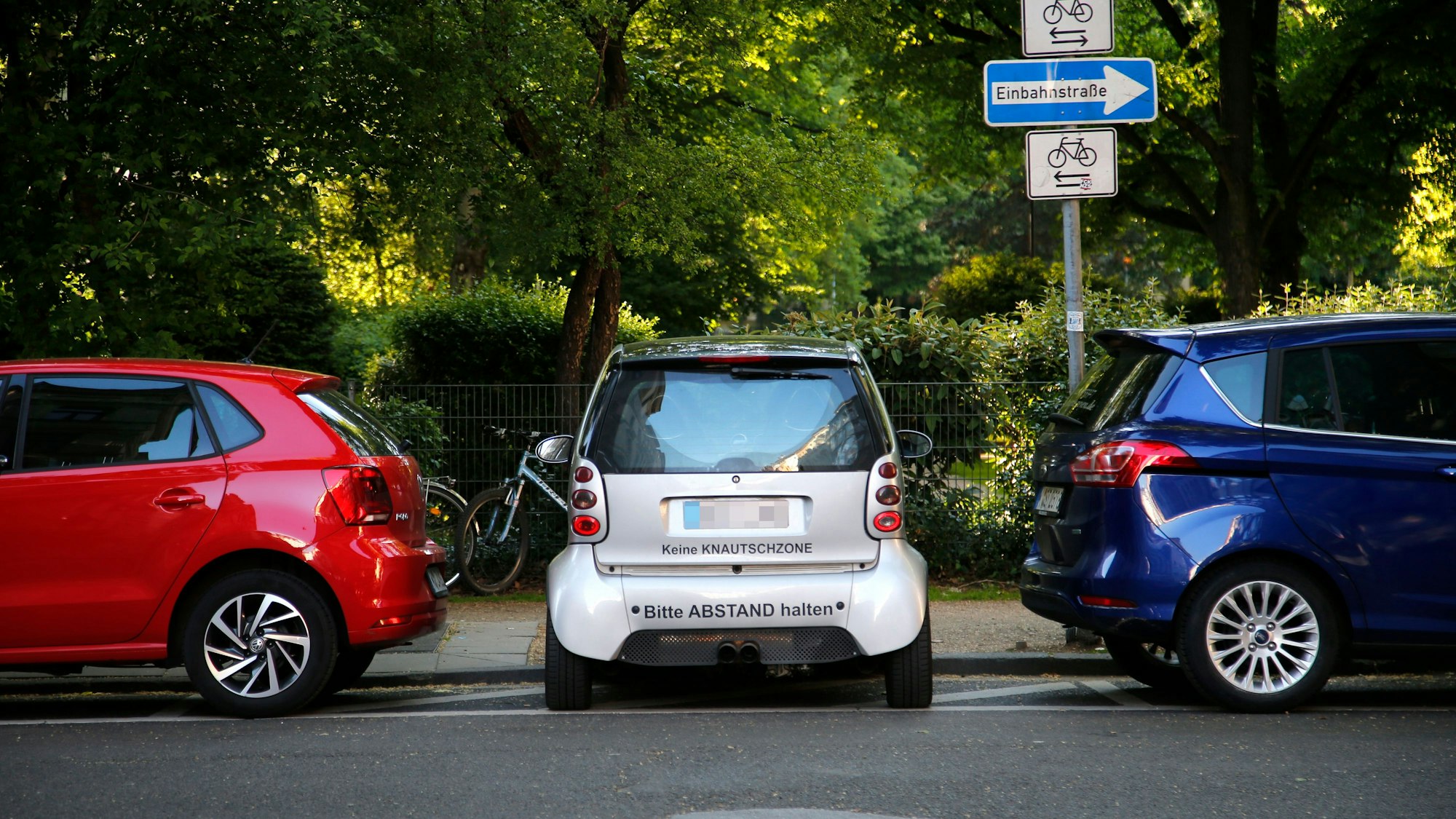 Geparkte Autos stehen in Köln am Straßenrand.
