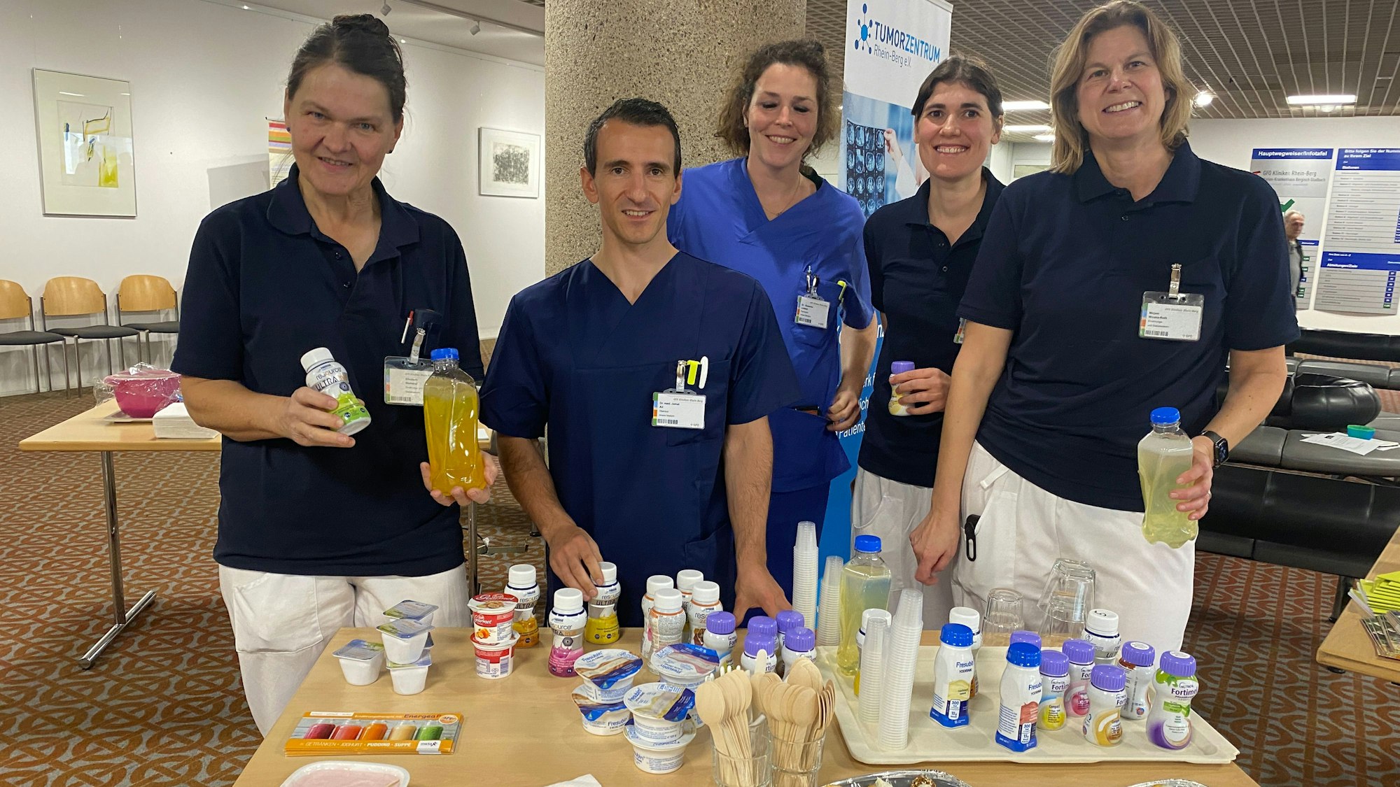 Ein Team des Marienkrankenhauses steht an einem Tisch mit Lebensmittel, die auch kranke Menschen gut essen können.
