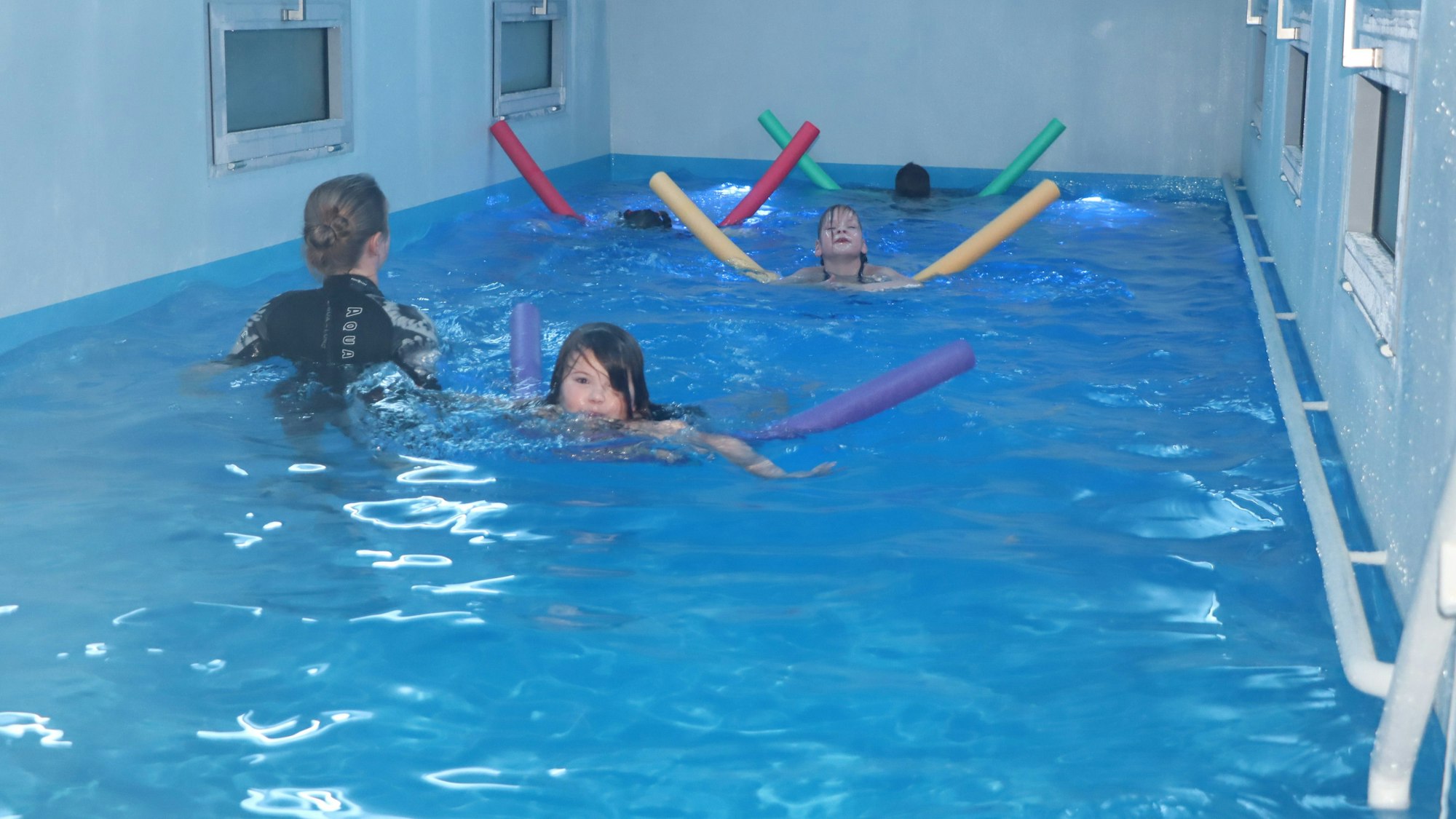 Auf dem Foto sind Kinder zu sehen, die im Schwimmcontainer unterrichtet werden.