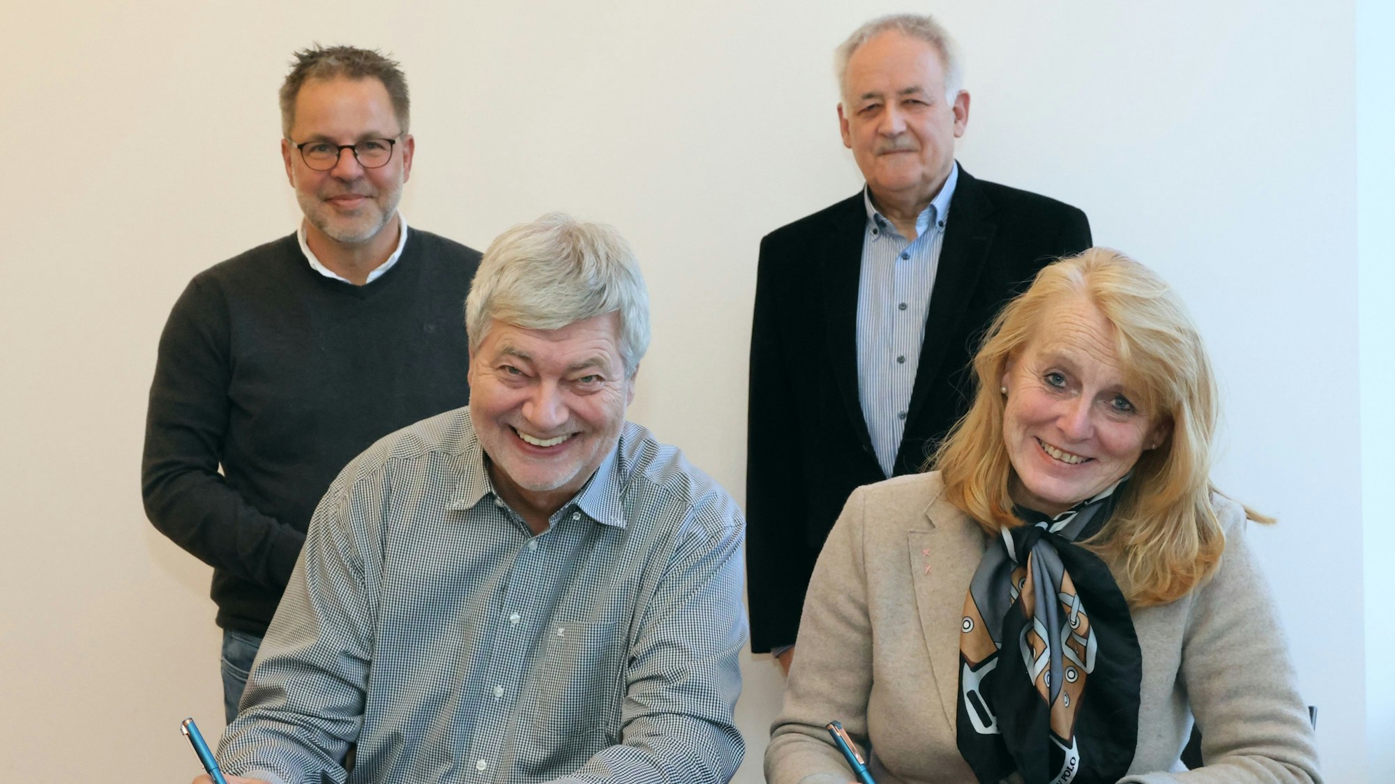 Hilko Redenius und Monika Lichtinghagen-Wirths sitzen an einem Tisch vor Dokumenten, die sie mit ihrer Unterschrift versehen.