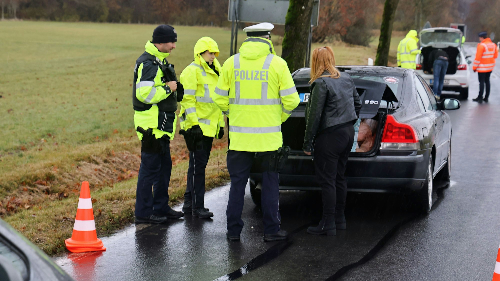 Polizeibeamte überprüfen zwei gestoppte Pkw.