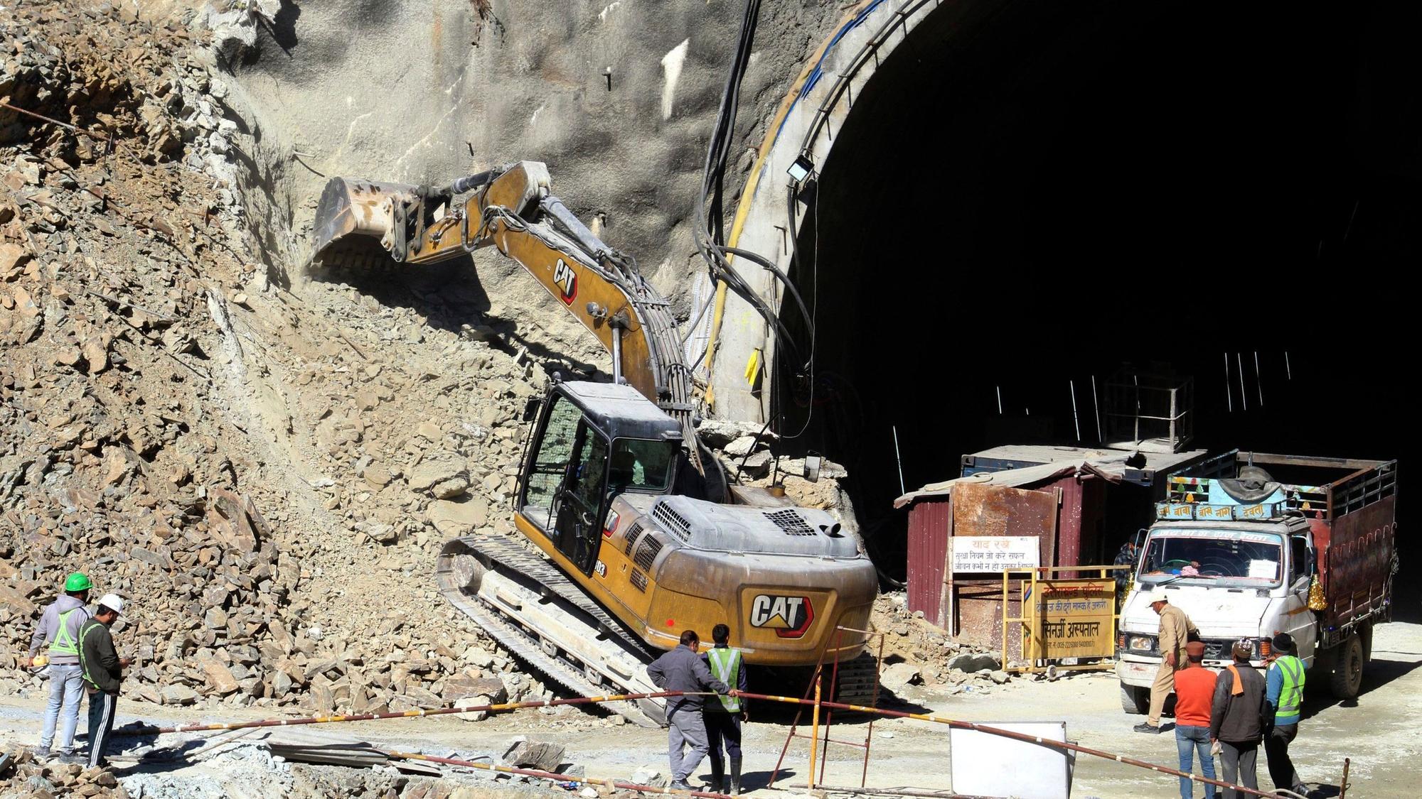 18.11.2023, Indien, Uttarakhand: Ein Bagger arbeitet am Eingang eines im Bau befindlichen Straßentunnels, der eingestürzt ist. Die Bohrarbeiten zur Rettung von etwa 40 Arbeitern in einem eingestürzten Autobahntunnel im Norden Indiens sind vorübergehend unterbrochen worden. Ein eigens aus der Hauptstadt Neu Delhi eingeflogenes Bohrgerät habe am Freitagnachmittag (17.11.2023) seine Arbeit eingestellt, nachdem ein lautes Knacken im Tunnel zu hören gewesen sei, berichtete die Nachrichtenagentur PTI am Samstag unter Verweis auf Behörden. Das Geräusch habe Panik bei den Rettungskräften ausgelöst. Foto: ---/AP/dpa +++ dpa-Bildfunk +++