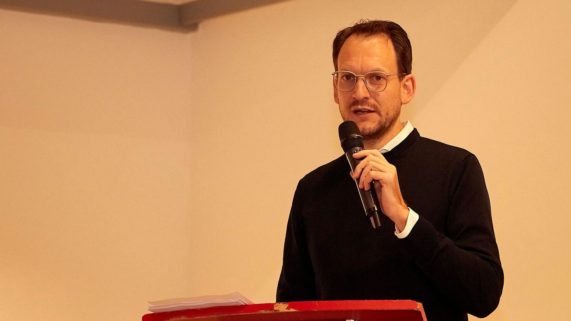 Thilo Waasem spricht beim Kreisparteitag und hält ein Mikrofon in der Hand.