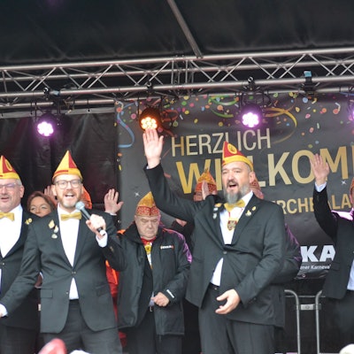 Die designierten Euskirchener Tollitäten Riccardo Mota Ramos (v.l.), Martin Niessen, Tobias Wiesen und Sascha Kremp stehen auf der Bühne, im Hintergrund weitere Karnevalisten.