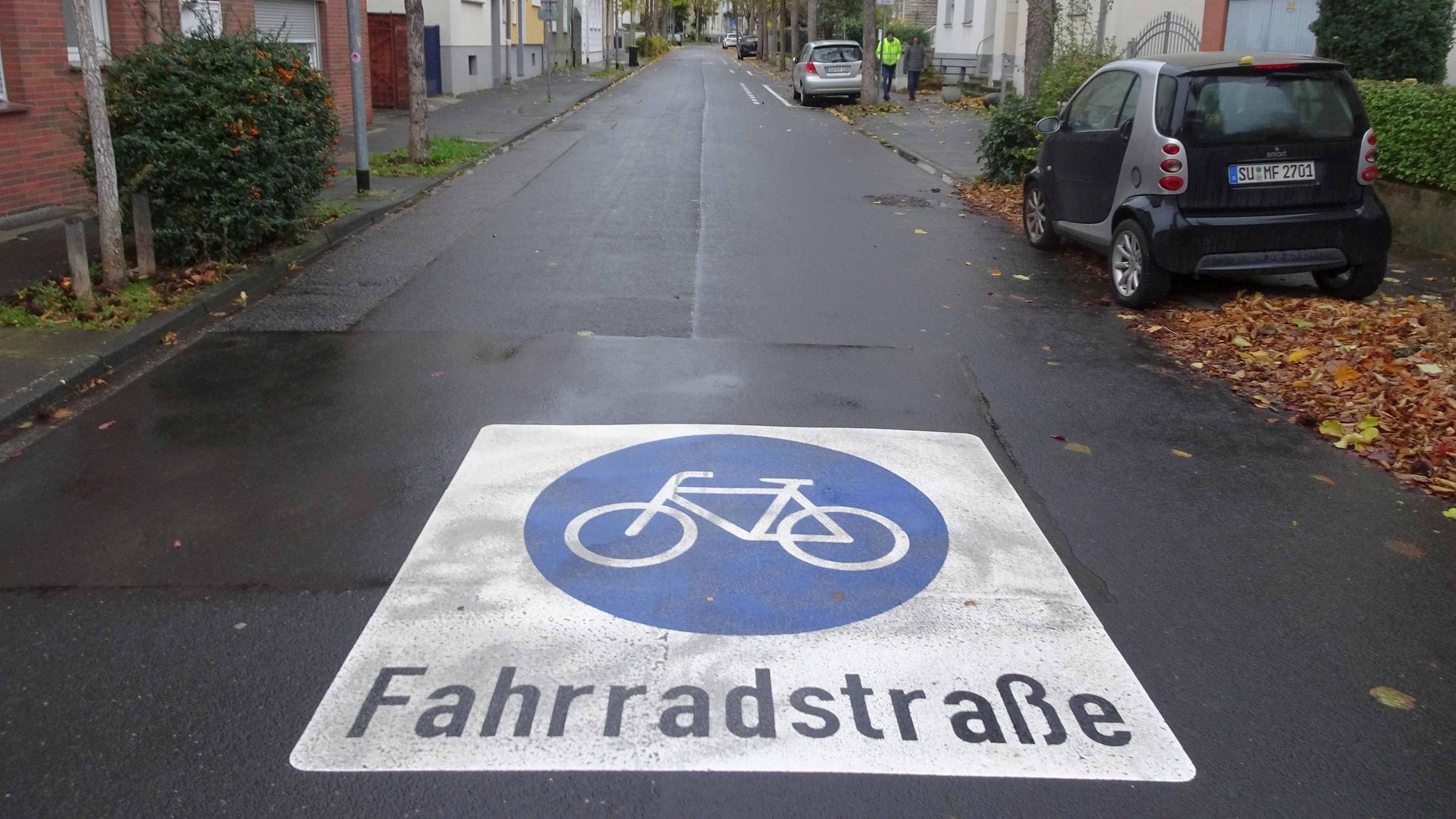 Bodenmarkierungen sind angebracht, Sicherheitstrennstreifen zu Parkplätzen markiert und Übergänge an Einmündungen rot eingefärbt: Die Kriegerstraße in Rheinbachs Innenstadt (Foto) ist eine von mehreren Straßen, die nun zu Fahrradstraßen wurden. Die Konsequenz ist hier weniger Autoverkehr. Überraschung für die Bürger: Nur Anlieger dürfen die Fahrradstraßen mit dem Auto benutzen. Wichtig: Die gestrichelten Linien neben Parkplätzen sind keine Schutzstreifen für den Radverkehr, sondern Sicherheitsstreifen. Radfahrer sollen links davon fahren, um zu vermeiden, in plötzlich aufgehende Türen parkender Autos hineinzufahren.