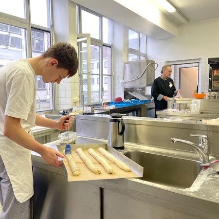 Das Foto zeigt Azubi David in der Lehrbackstube des Berufskollegs.