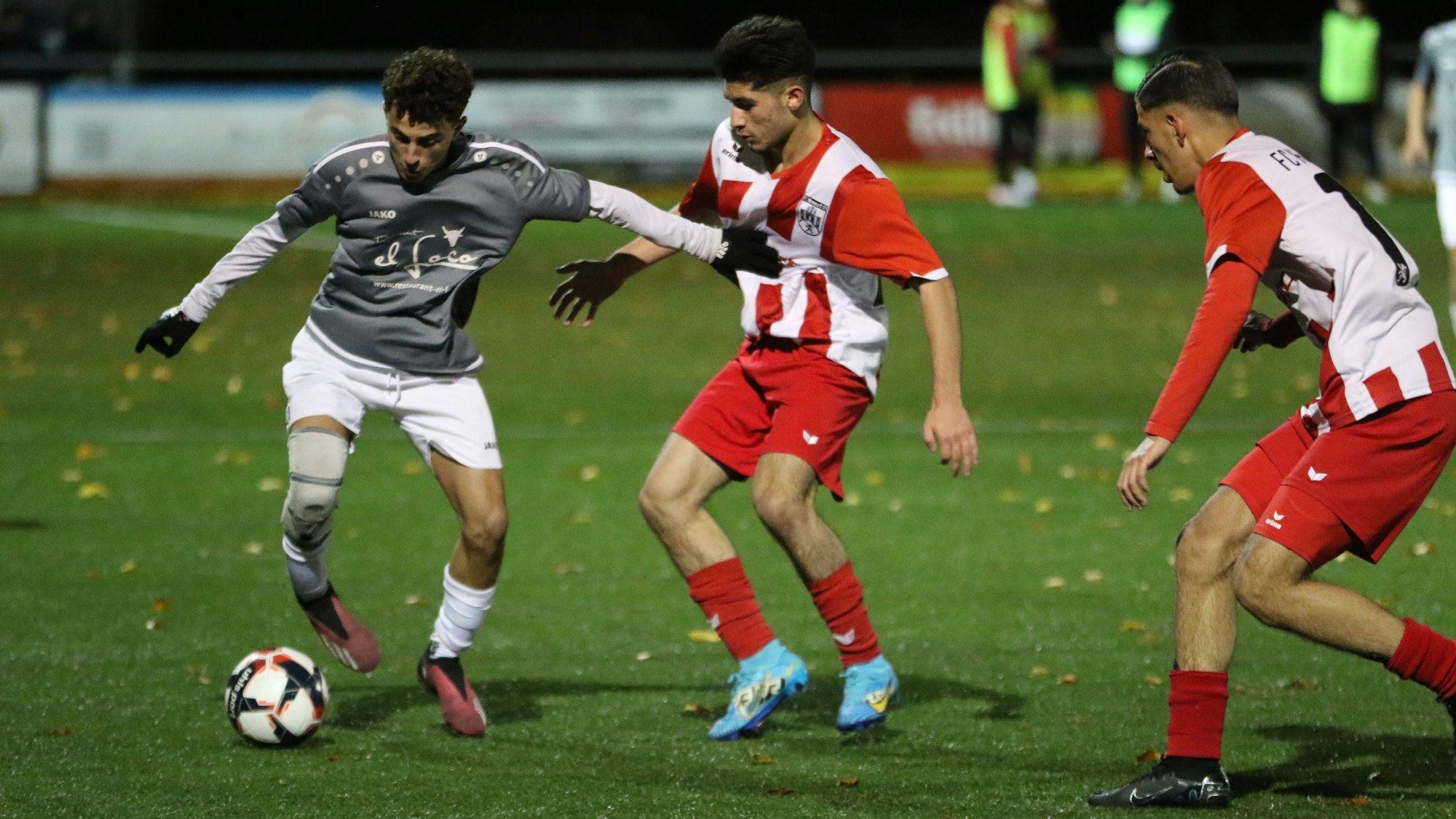 Ein Spieler der JSG Erft 01 hält mit ausgestrecktem Arm einen Gegenspieler auf Abstand.
