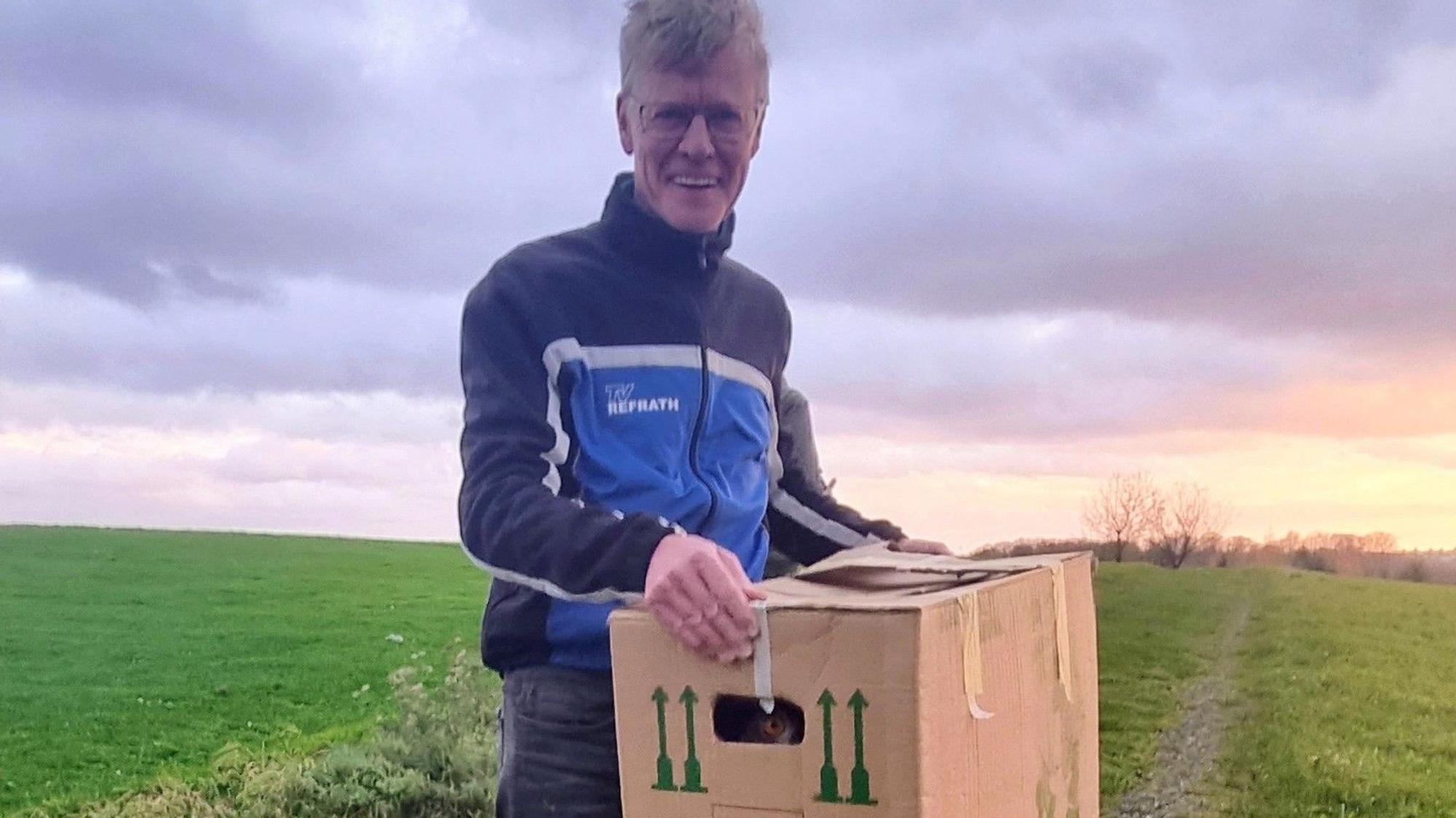 Das Foto zeigt Jochen Baumhof mit einem Uhu, der nach Heilung in die Freiheit in die Freiheit entlassen wird