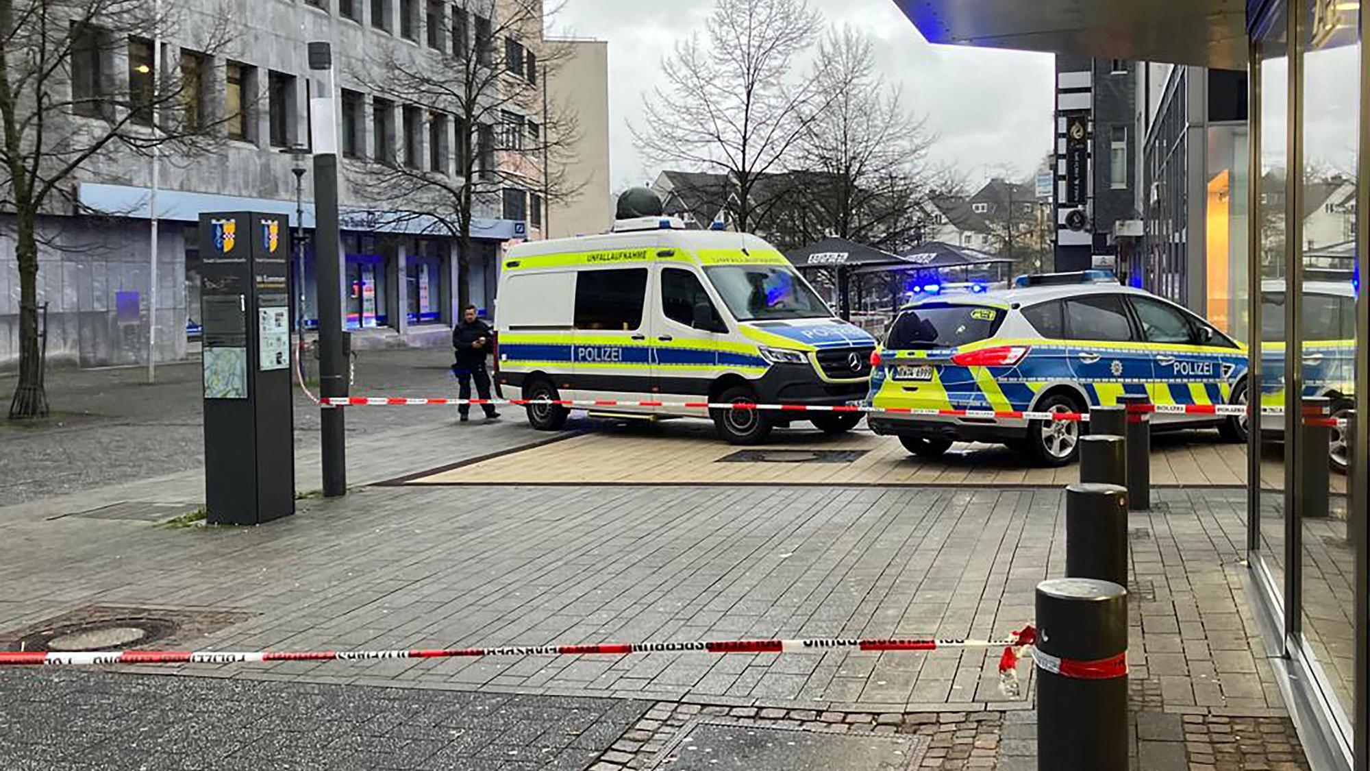 Zwei Polizeiautos stehen auf einer Fußgängerzone. Es ist Absperrband zu sehen.