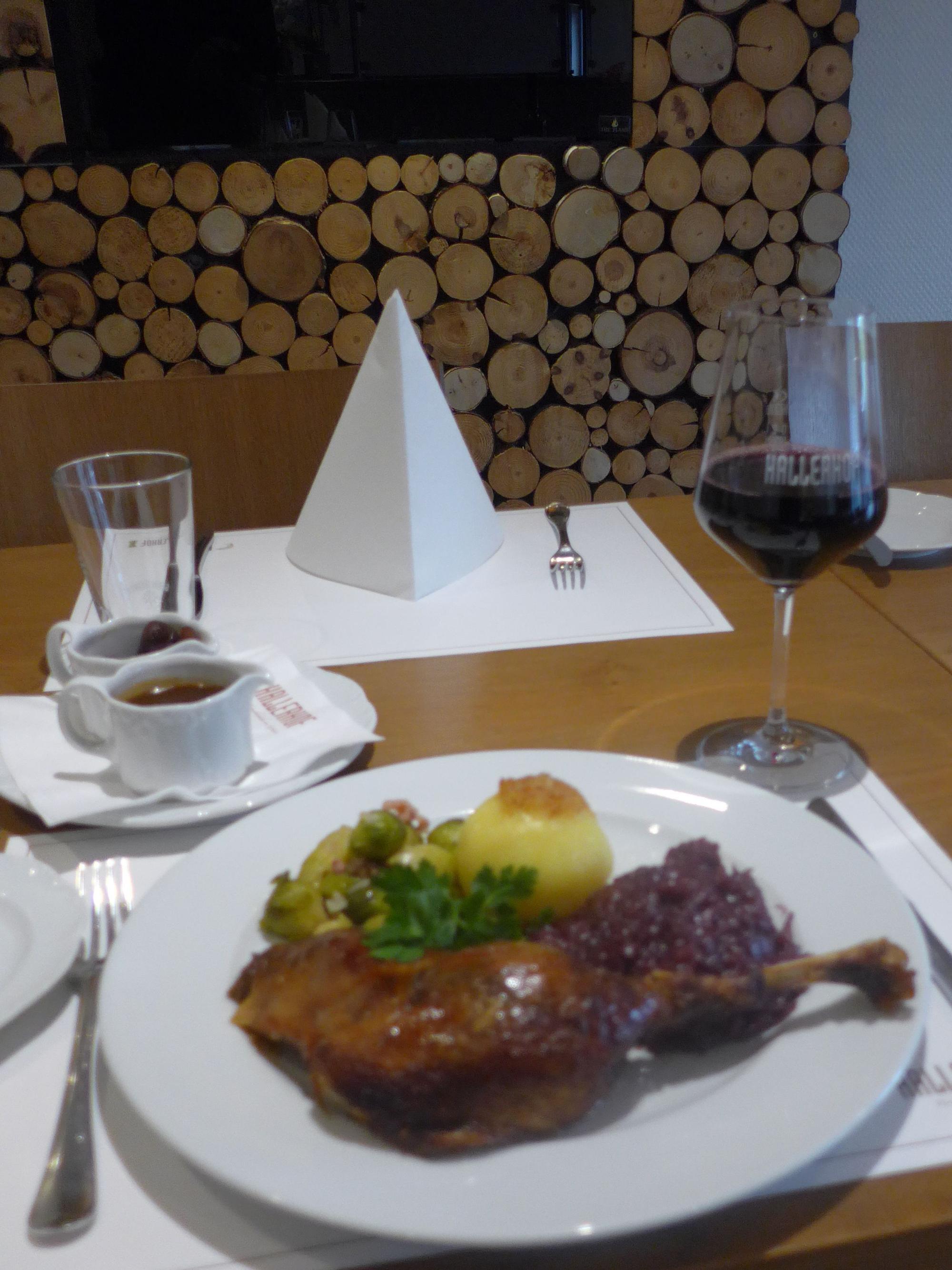 Das Bild zeigt einen gedeckten Tisch mit Gans und einem Glas Rotwein.