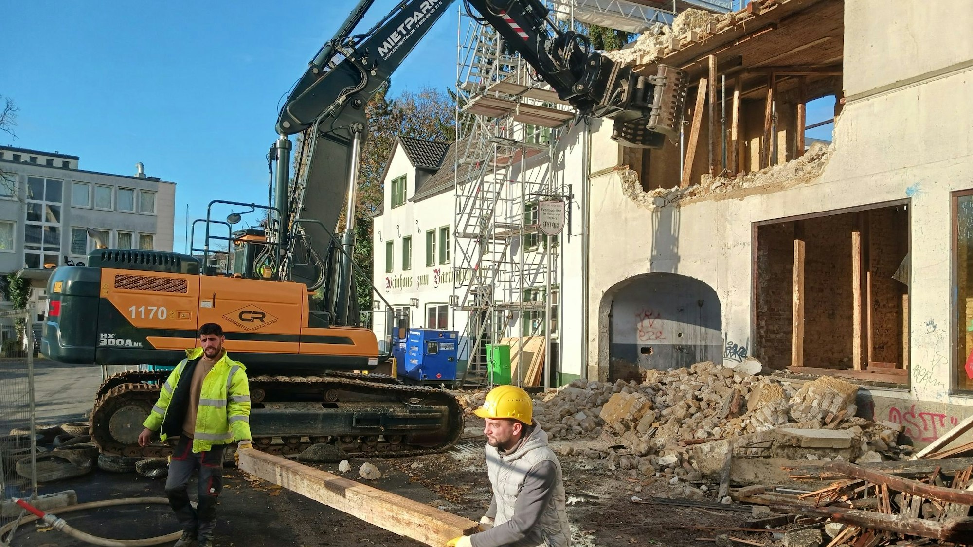 Mit einem Bagger wird ein altes Haus abgerissen