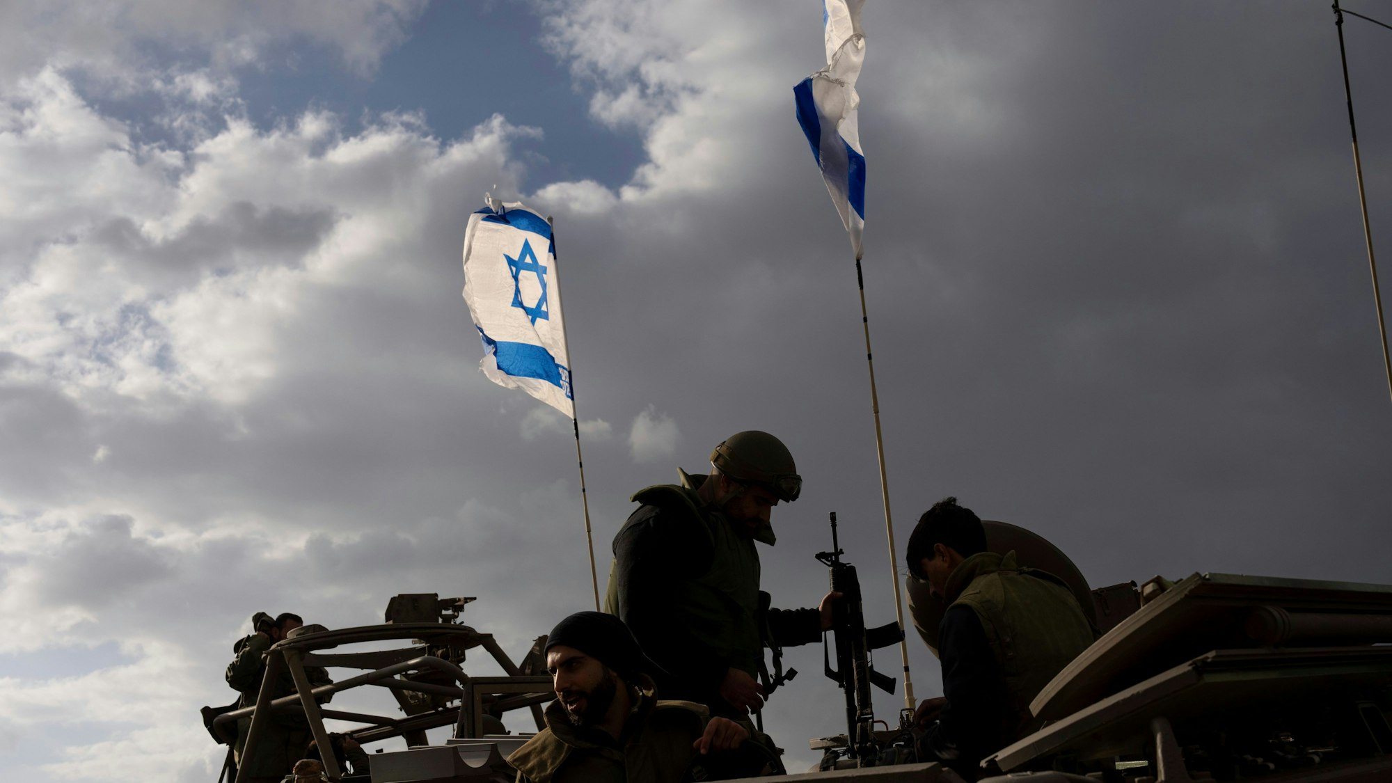 Israeli soldiers work on an armored military vehicle along Israel's border with the Gaza Strip, in southern Israel, on Monday, Nov. 20, 2023. The Israeli military has deployed hundreds of thousands of troops in and around Gaza as it conducts a ground offensive against Hamas militants inside the territory. (AP Photo/Ohad Zwigenberg)