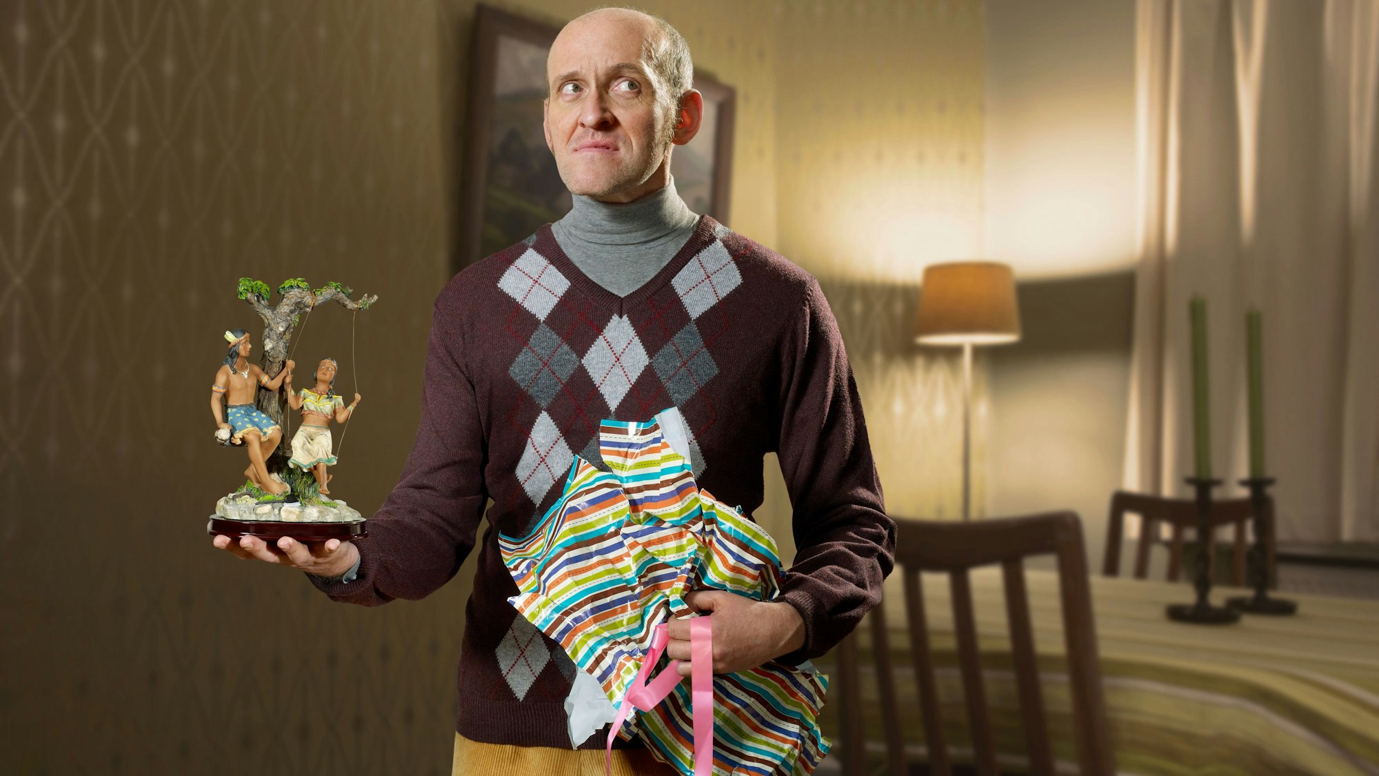 Mann mit Geschenk in der Hand, enttäuschtes Gesicht