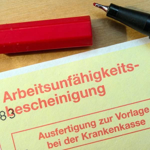 Eine Arbeitsunfähigkeitsbescheinigung liegt auf einem Tisch.