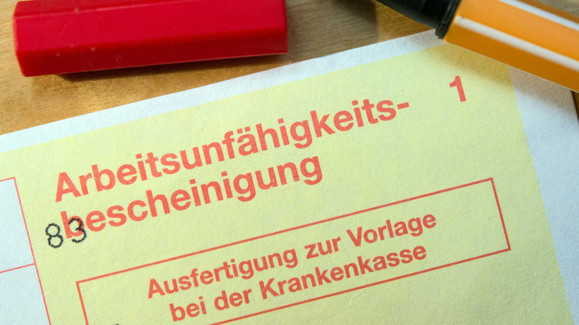 Eine Arbeitsunfähigkeitsbescheinigung liegt auf einem Tisch.