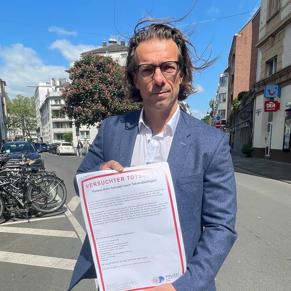 Dirk Bachem hält ein Plakat in der Hand auf dem „Versuchter Totschlag“ steht.