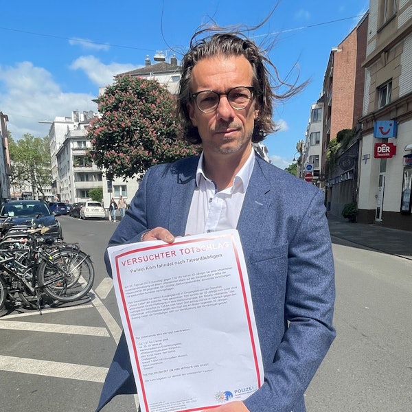 Dirk Bachem hält ein Plakat in der Hand auf dem „Versuchter Totschlag“ steht.